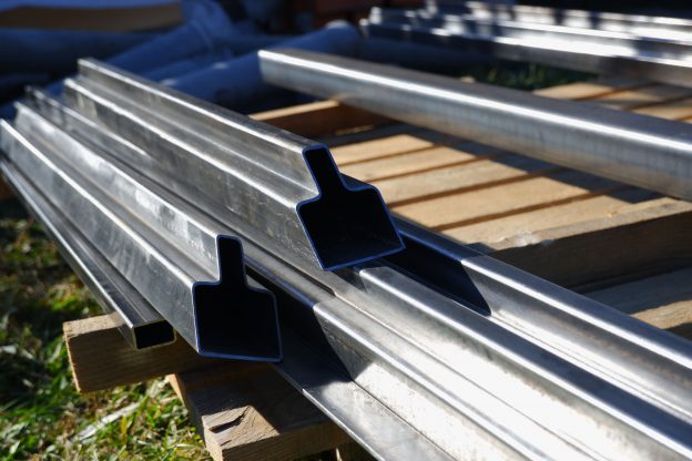 Chapas de aço galvanizado brilhantes empilhadas em galpão industrial