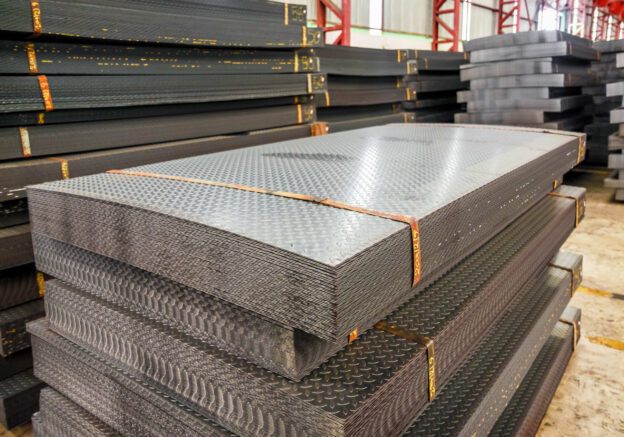 Chapas de aço carbono empilhadas em ambiente industrial, com superfície antiderrapante e alta resistência para diferentes aplicações.