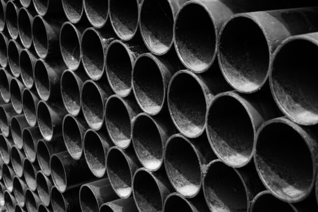 Tubos de aço empilhados utilizados em estruturas metálicas na construção civil e em projetos industriais, com alta resistência e durabilidade.