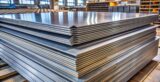 Chapas de aço empilhadas em ambiente industrial, utilizadas na construção civil e na fabricação de estruturas metálicas e equipamentos.